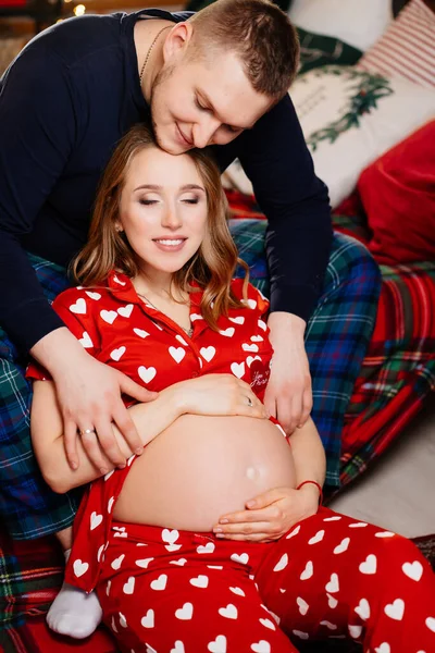 Aşık bir kadın ve erkek. Yeni yıl yatak odasında pijamalı bir aile. gebelik — Stok fotoğraf
