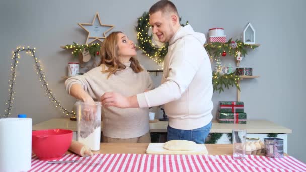 Hermosa mujer embarazada con su marido en la cocina de Año Nuevo prepara la masa. — Vídeos de Stock