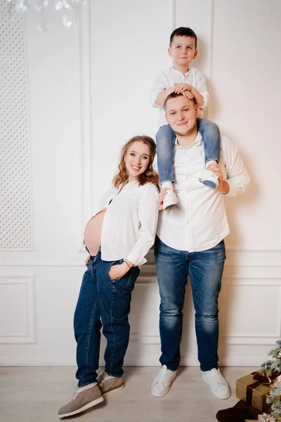 Lycklig familj. gravid mor med sin son och far i jeans och en vit skjorta — Stockfoto