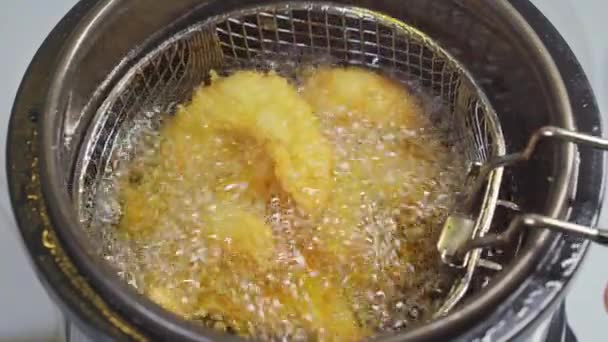 Z fritézy vytáhněte košík se smaženými krevetami v těstíčku. — Stock video