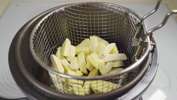 Картошку кладут во фритюрницу. приготовление картошки фри — стоковое видео