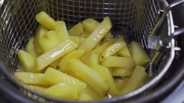 Patates sepeti fritözün içine konur. Patates kızartması pişirmek 