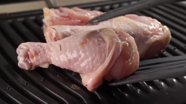 Trozos de pollo se ponen en una parrilla eléctrica para freír. — Vídeos de Stock