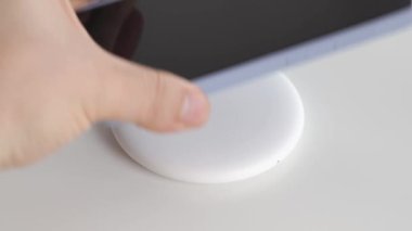 Akıllı telefon beyaz yuvarlak kablosuz şarj cihazına yerleştiriliyor. modern, 
