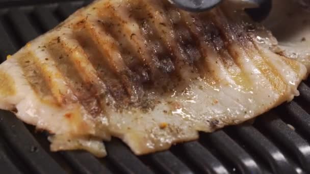Filé de peixe foi cozido em uma grade elétrica e removido do fogão. Tilápia. — Vídeo de Stock