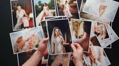 Eller düğün fotoğraflarını serer. Düğünde çalışan fotoğrafçıların sonuçları..
