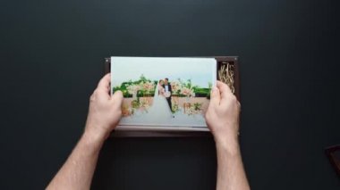 Fotoğrafçı düğün fotoğraflarını ve flaş belleği bir kutuya koyar.. 