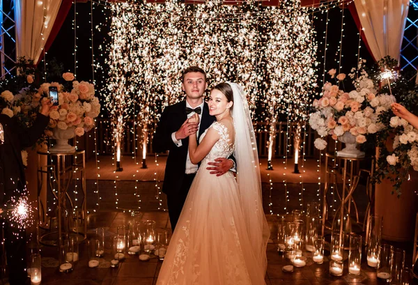 stock image the bride and groom on the night street among the garlands