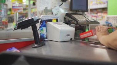 Dükkânın kasası. Kasiyer süpermarketteki alımları tarıyor.
