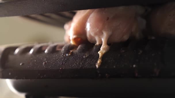 Кусочки курицы поджариваются в электрическом гриле. — стоковое видео