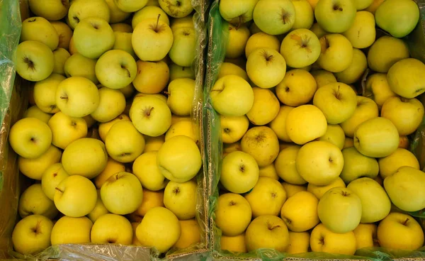 Süpermarketin vitrininde elma kutuları. Sebze reyonundaki meyveler