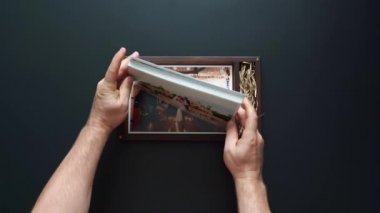 Fotoğrafçı düğün fotoğraflarını ve flaş belleği bir kutuya koyar.. 