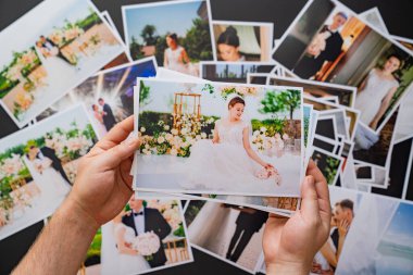 Eller düğün fotoğraflarını serer. Düğünde çalışan fotoğrafçıların sonuçları..