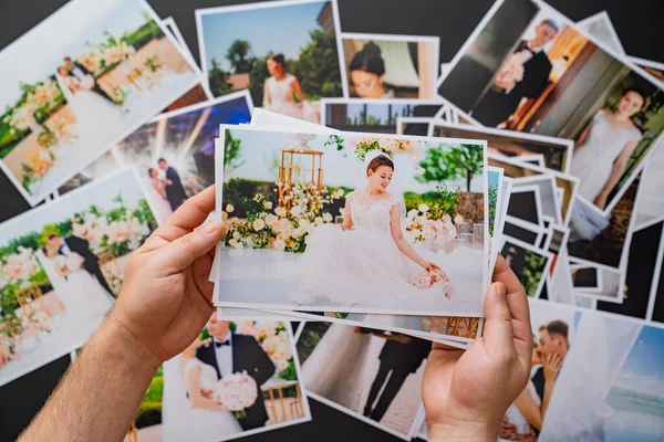 Hands lay out wedding photos. the result of the photographers work at wedding. — Stock Photo, Image