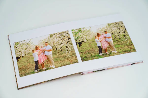 Fundo branco fotolivro aberto da sessão de fotos da família no jardim da primavera — Fotografia de Stock