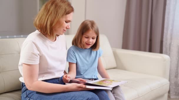 Mother and daughter watch photobook family photo shoot in spring garden — Stock Video