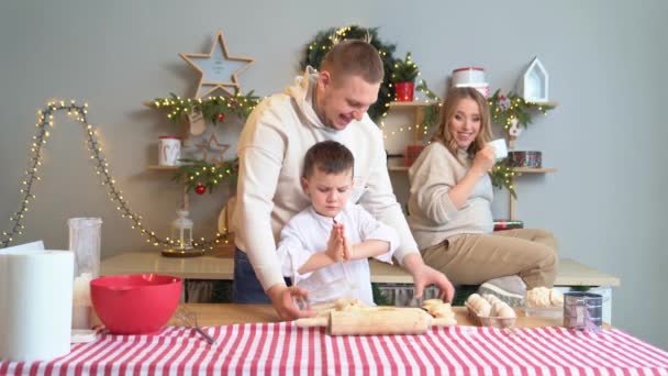 Gelukkig gezin samen bereidt traditionele gerechten uit het deeg voor het nieuwe jaar. — Stockvideo
