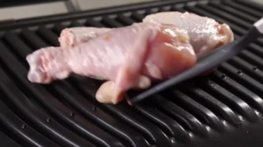 Tavuk parçaları kızartmak için elektrikli ızgaraya konur.. 