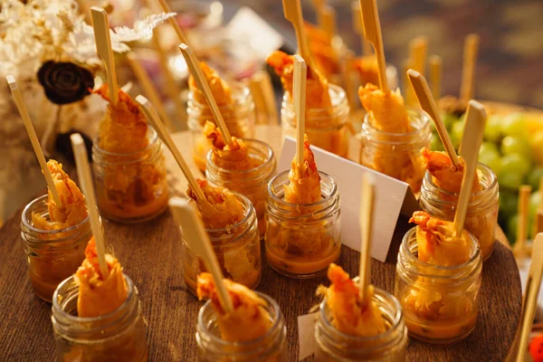 Servir camarones con salsa en porciones en pequeños frascos de vidrio. buffet de vacaciones. —  Fotos de Stock