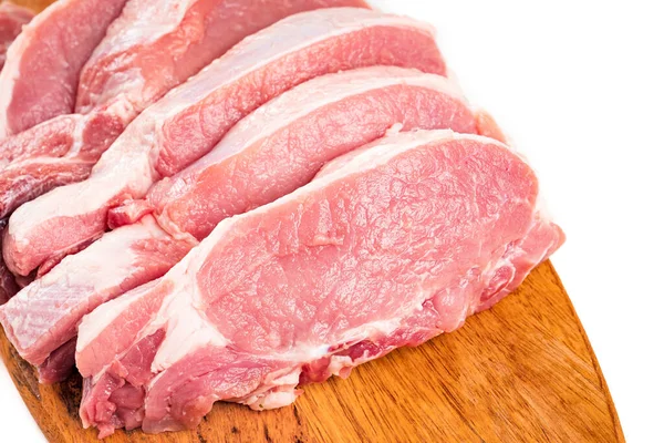 Beyaz arka planda tahta bir kesme tahtasının üzerinde dilimlenmiş çiğ domuz eti.. — Stok fotoğraf