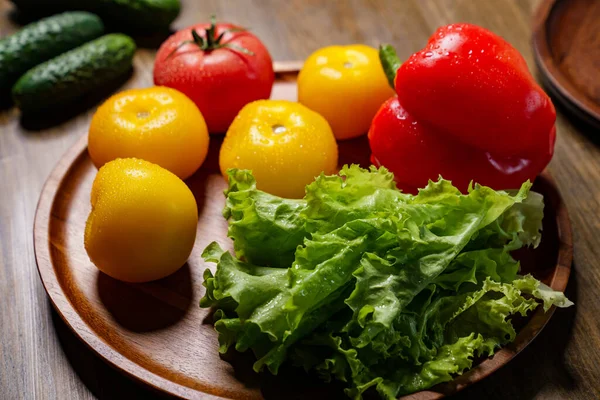 Alface, tomates amarelos e vermelhos e pimentão com gotas de água. pepinos. — Fotografia de Stock