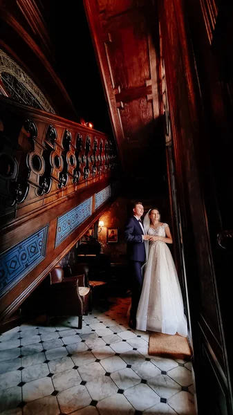 Bride and groom in the sunlight at the glass door. beautiful and happy wedding. — Stock Photo, Image