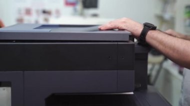 Adamın biri fotokopi makinesinde belgeleri kopyalıyor. ofis ve ev için ekipman