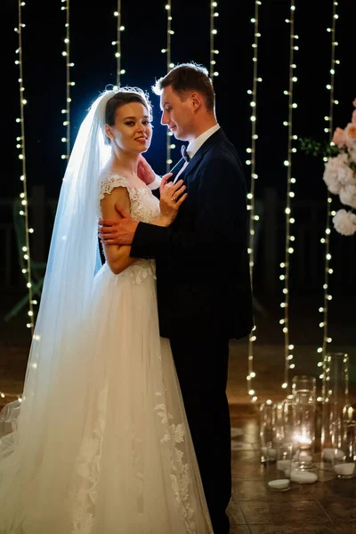 Gelin ve damat akşam düğününde parkta ampullerin arasında. — Stok fotoğraf