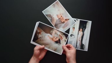 Eller düğün fotoğraflarını serer. Düğünde çalışan fotoğrafçıların sonuçları..