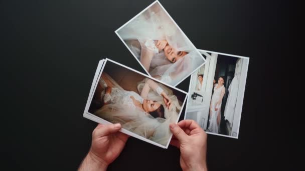 Handen leggen trouwfoto 's uit. het resultaat van het werk van de fotografen op de bruiloft. — Stockvideo