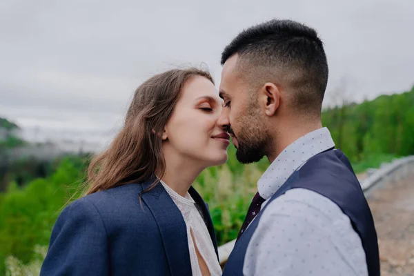 Bruden och brudgummen kysser varandra ömt i naturen. romantik i förhållandet — Stockfoto