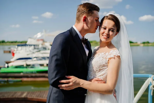 Frischvermählte auf dem Pier. Hochzeit am Wasser oder auf einer Jacht. — Stockfoto