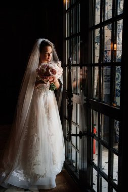 Pencerenin yanındaki karanlık odada güzel ve nazik bir gelin.. 