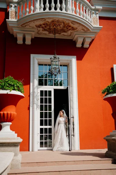 a beautiful and gentle bride at the door to the retro building