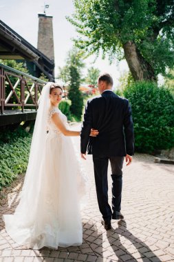 Dikiz aynası. Gelin ve damat parkta el ele yürürler..