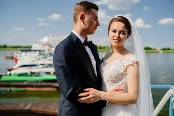 Frischvermählte auf dem Pier. Hochzeit am Wasser oder auf einer Jacht. — Stockfoto