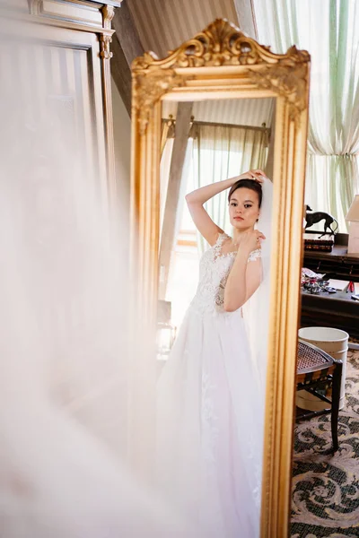 La novia en el espejo. enfoque selectivo. probarse un vestido de novia — Foto de Stock