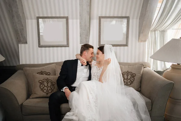 Alegre e feliz noiva e noivo no sofá. um casamento divertido. — Fotografia de Stock