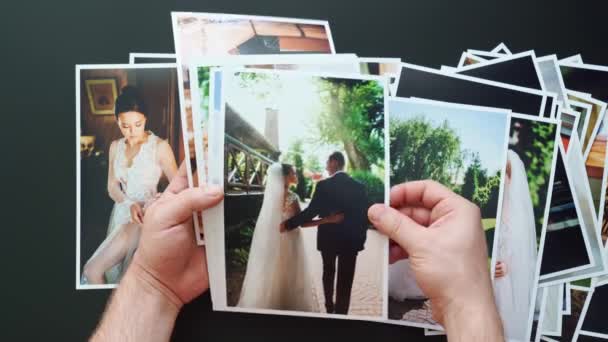 Handen leggen trouwfoto 's uit. het resultaat van het werk van de fotografen op de bruiloft. — Stockvideo