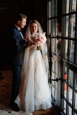 Gelin ve damat güneş ışığında cam kapıda. Güzel ve mutlu bir düğün.. 