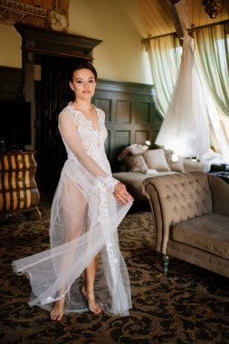 Dantelli bir bornozla, içi retro bir odada güzel bir gelin..