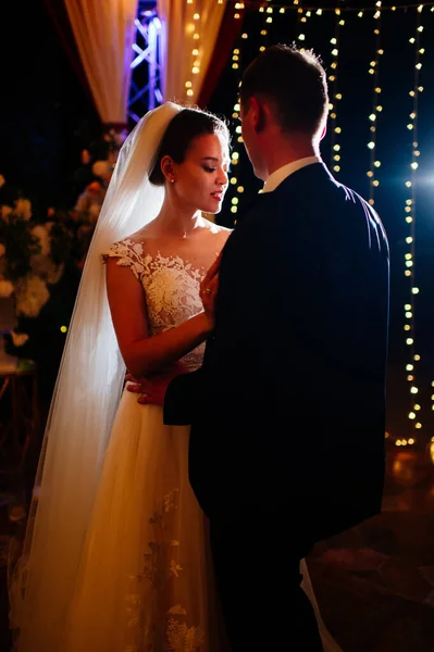 Gelin ve damat akşam düğününde parkta ampullerin arasında. — Stok fotoğraf