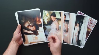 Eller düğün fotoğraflarını serer. Düğünde çalışan fotoğrafçıların sonuçları..