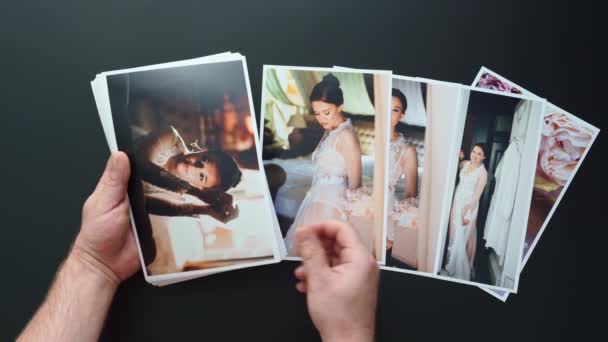 손으로 결혼식 사진을 펼쳐 놓는다. 결혼식에서 사진 기자들 이 일 한 결과. — 비디오