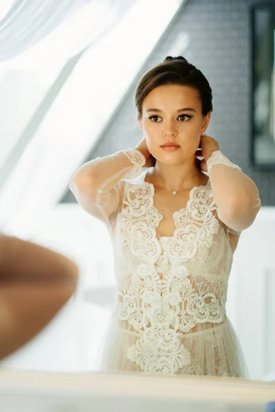 Una hermosa joven con una túnica de encaje junto al espejo — Foto de Stock