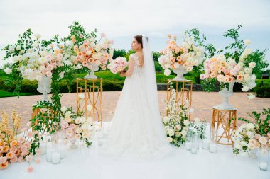 Gelin, canlı beyaz ve pembe çiçeklerin düğün alanında.. 