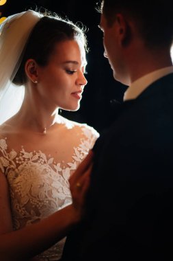 Gelin ve damat akşam düğününde parkta ampullerin arasında.