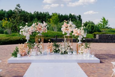 Çiçeklerin açık havasında, mumlarla birlikte düğün töreni.