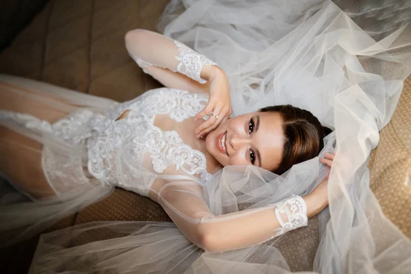 레이스 를 단 겉옷을 입은 유순 한 신부는 베일 위에 누워 있다. 결혼식 전 오전. — 스톡 사진
