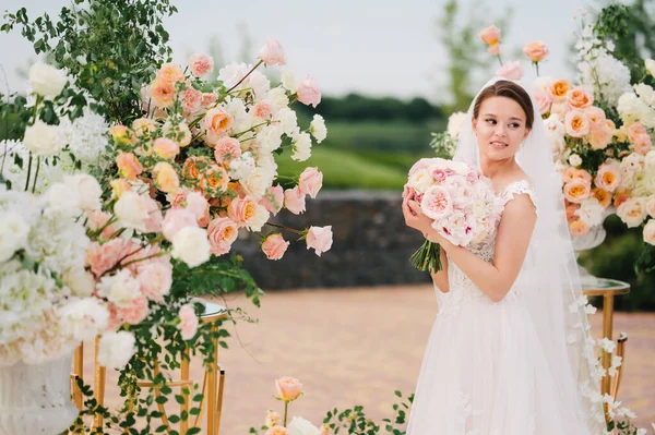 Gelin, canlı beyaz ve pembe çiçeklerin düğün alanında.. — Stok fotoğraf